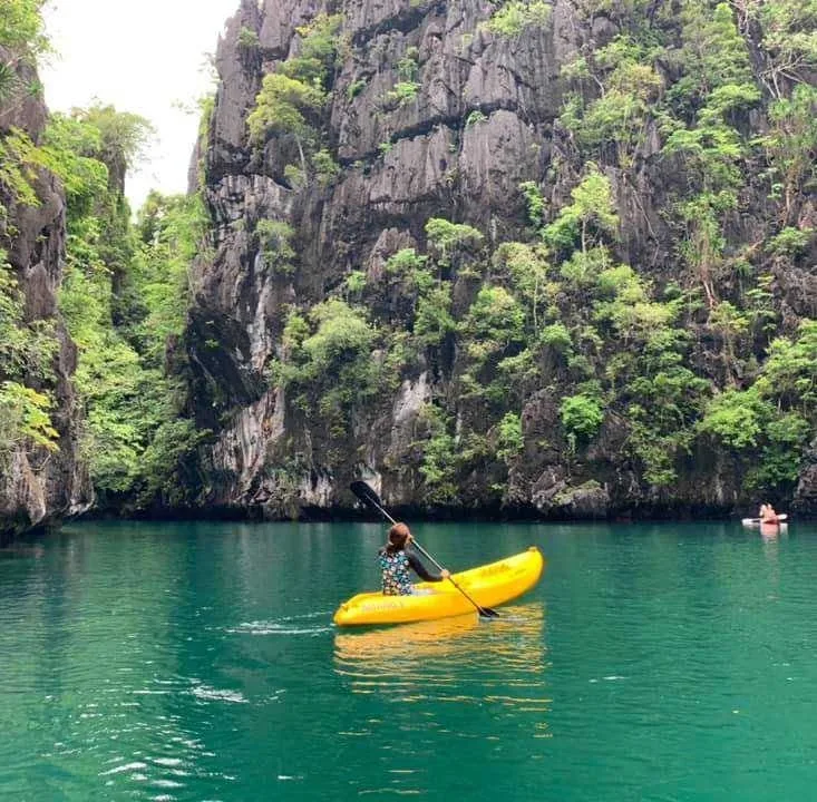 A guest kayaking past the limestone cliffs of El Nido, where swiftlets build their nests