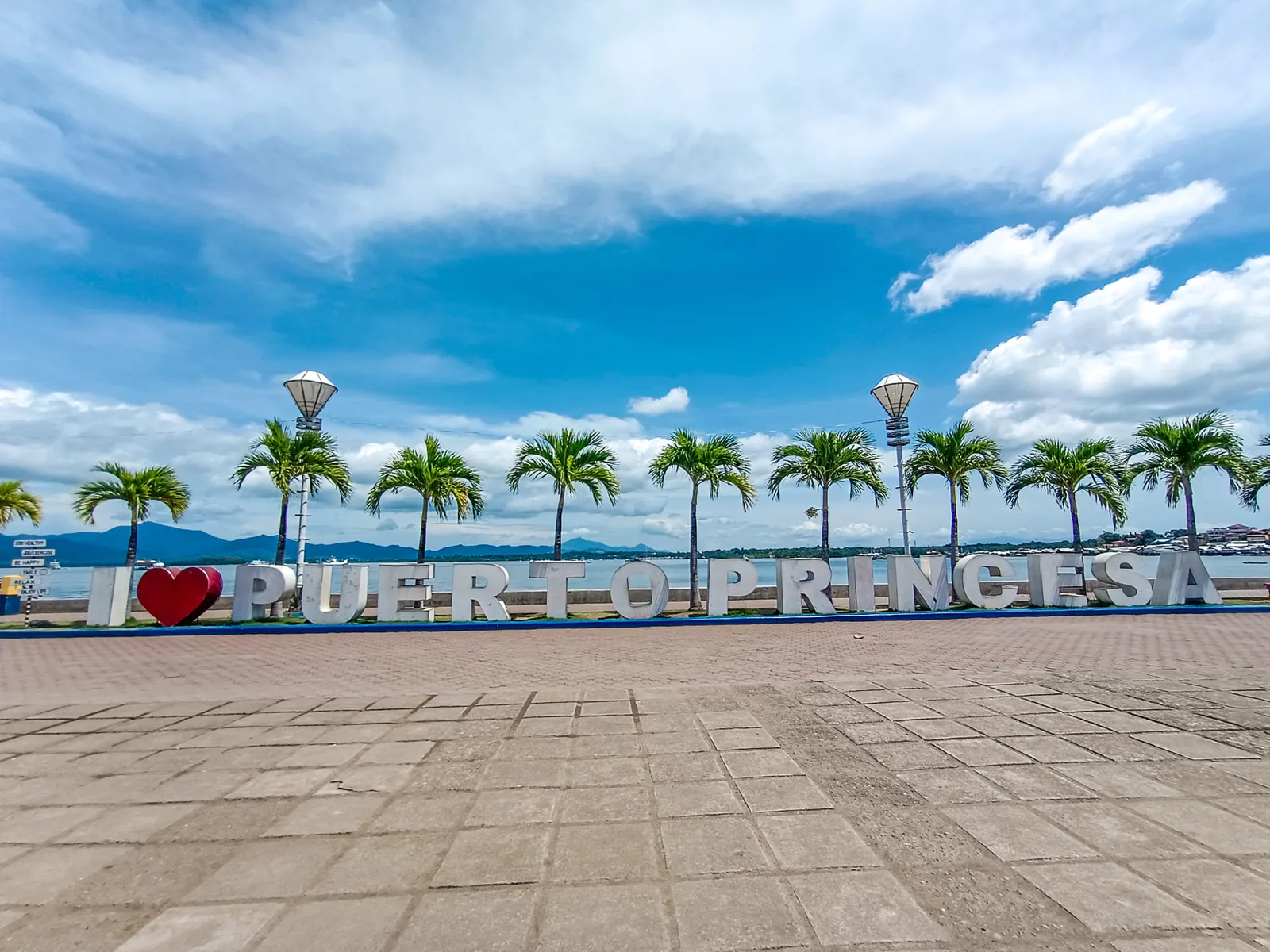 The I Love Puerto Princesa sign and palm trees along the Puerto Princesa Baywalk